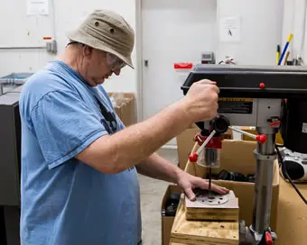 Worker using drill press