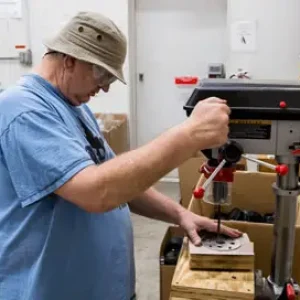 Worker using drill press
