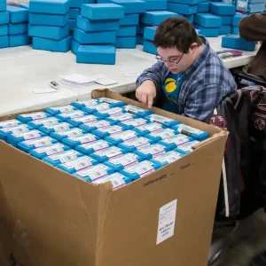Worker performing light assembly tasks at Christian County Enterprises facility